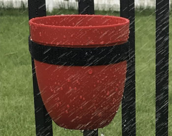 Red plastic pot in the rain. Shows it is weatherproof.